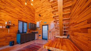 A wooden cabin interior with a kitchen, a dining area, and a staircase. - SAPANCA GRANDWOODEN SUİT  (Sapanca)