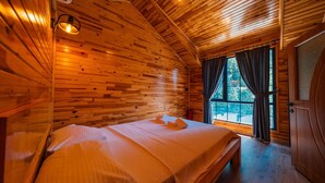 A wooden cabin room with a bed, a window, and a door. - SAPANCA GRANDWOODEN SUİT  (Sapanca)