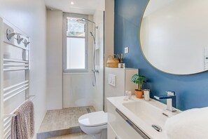 Une salle de bain moderne équipée d’une douche, de toilettes et d’un lavabo.