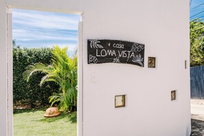 Una pared blanca con un letrero que dice 'casa LOMA VISTA' y una ventana pequeña.