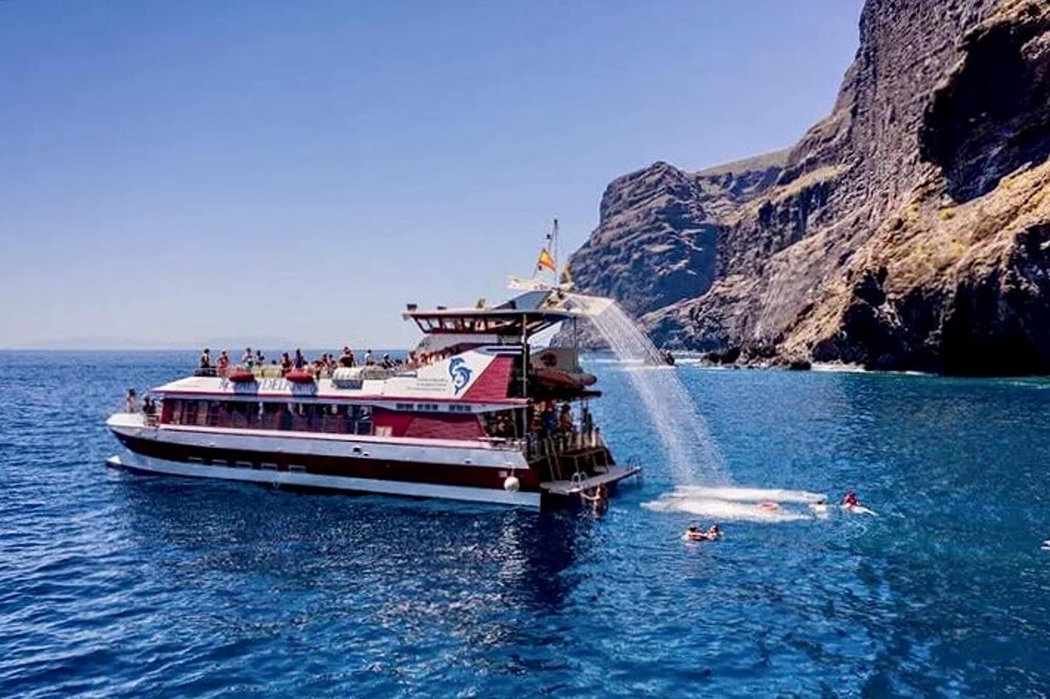A boat with passengers and a waterfall.