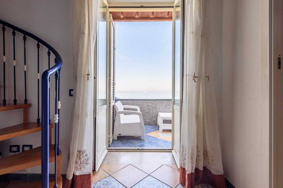 Un escalier menant à un balcon d’où l’on peut admirer la mer.