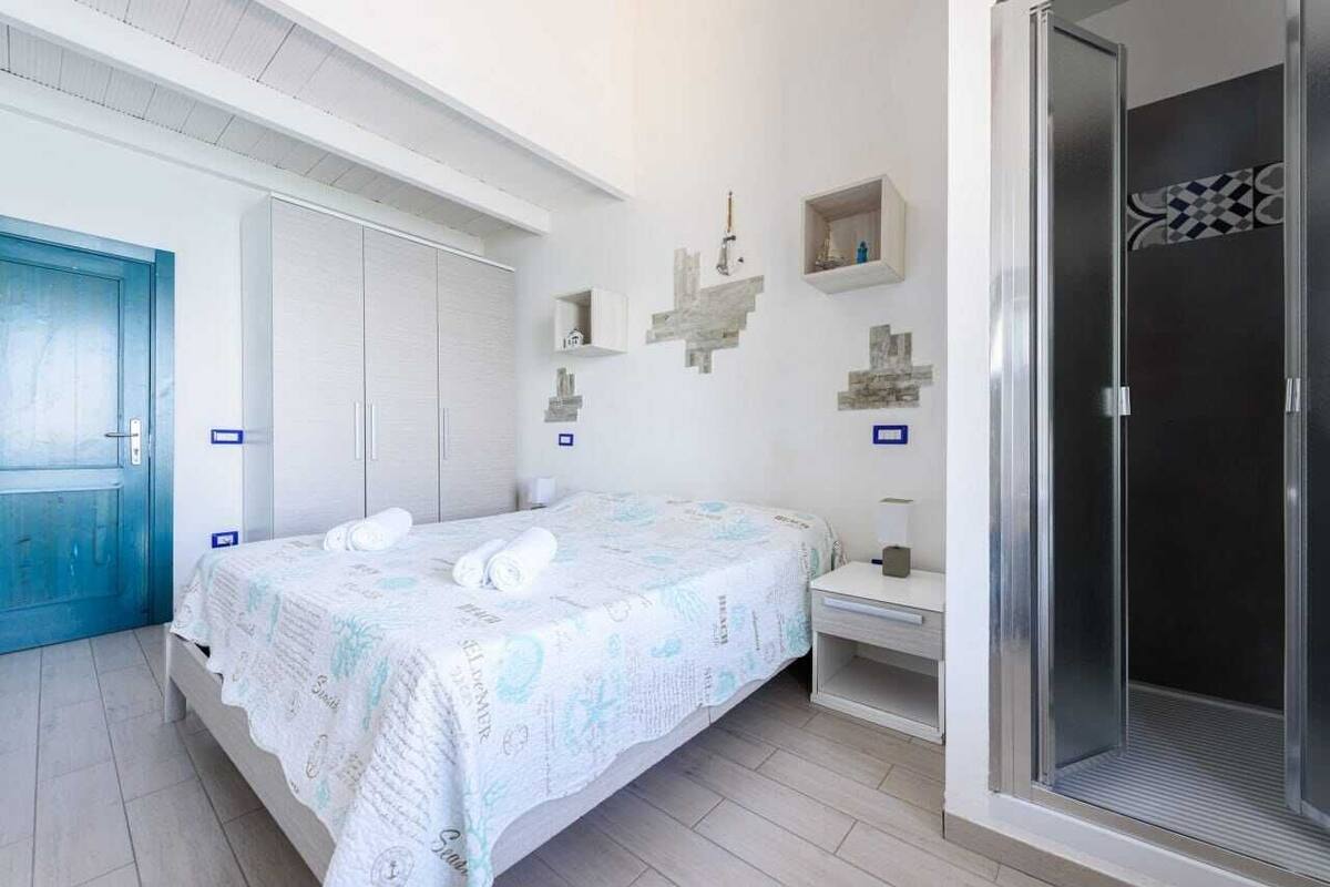 Une chambre à coucher avec un lit, une salle de bain et un espace douche.