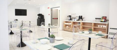 A modern dining area with clear chairs, white tables, and a minimalist design.