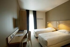 A hotel room with two single beds, a desk with a chair, and a wardrobe. - VICTOR HOTEL (Bari)