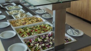 A buffet with various dishes and a glass-top serving area. - Gennadi Sea Side Resort (Rhodes)