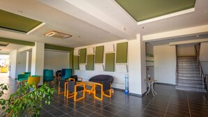 A modern lobby with a staircase, seating area with chairs, and a water dispenser. - Gennadi Sea Side Resort (Rhodes)