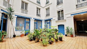 A courtyard with potted plants and a tiled floor.