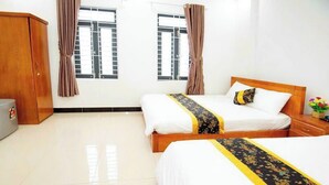 A hotel room with two beds, a wardrobe, and a window with curtains. - Moonlight Quynhon Hotel (Quy Nhon Nam)
