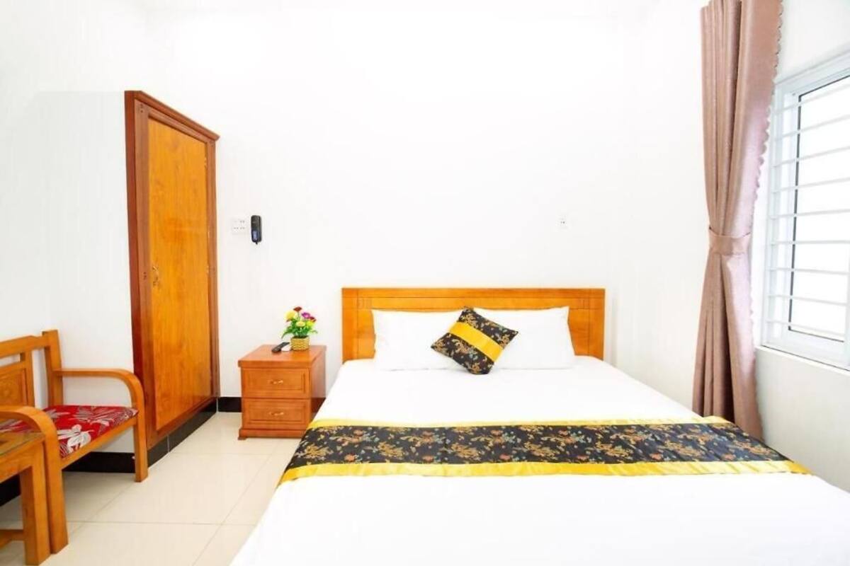 A bedroom with a wooden bed, a nightstand, a chair, and a wardrobe.