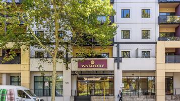 A multi-story building with a sign reading "Waldorf."
