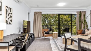 A modern living room with a large window, a dining area, and a seating arrangement. - Luxury Perth Getaway: Modern Design (Perth WA)