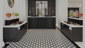 A modern kitchen with a central island, dark cabinetry, and a patterned floor. - Elegant Hotel (Hue)