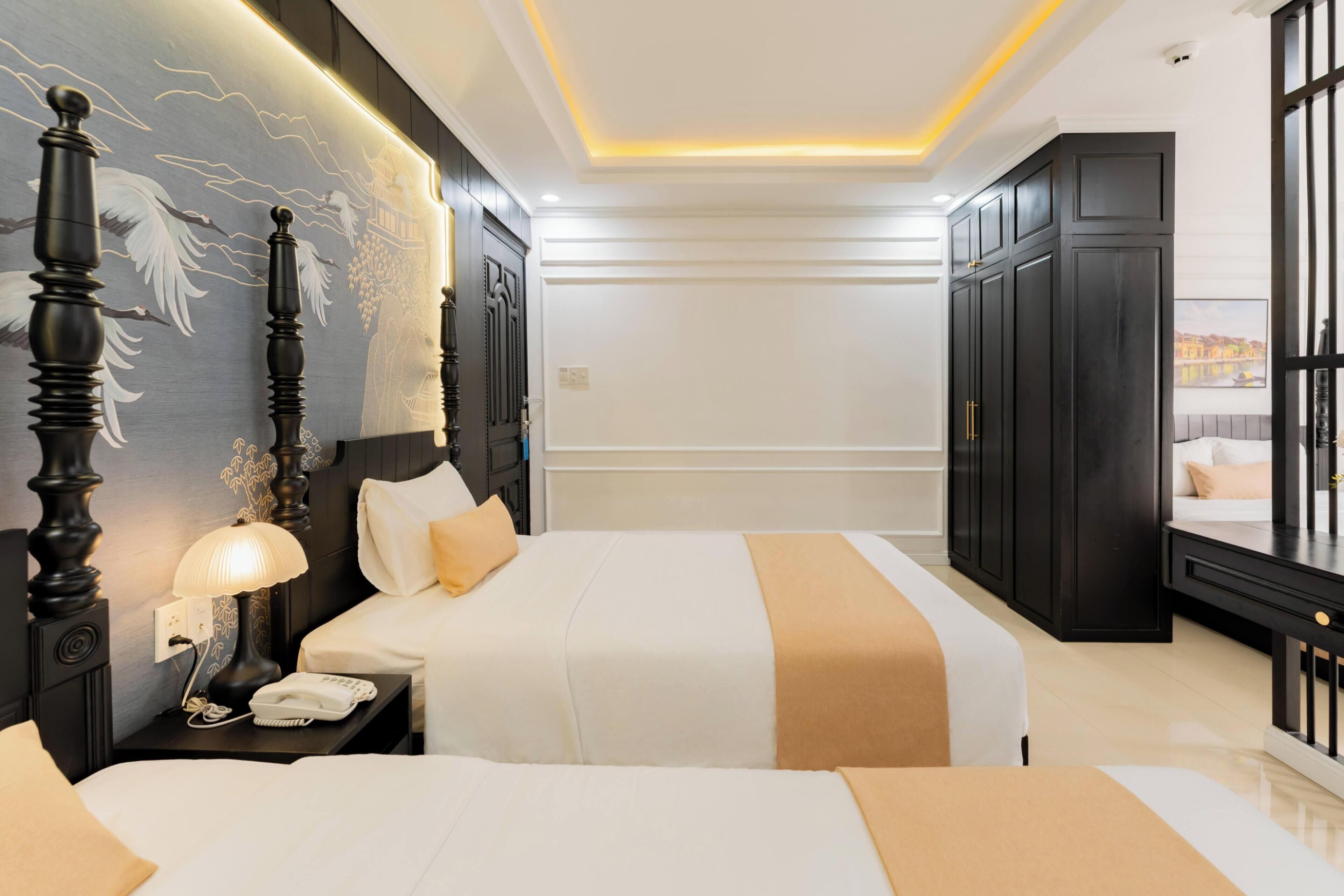 A hotel room with two beds, a nightstand with a lamp, a wall-mounted telephone, and a large window with a view.