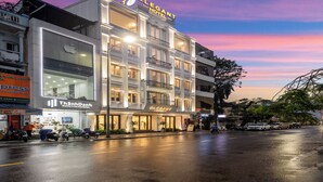 A multi-story hotel with a prominent "ELEGANT HOTEL" sign, large windows, and a modern facade. - Elegant Hotel (Hue)