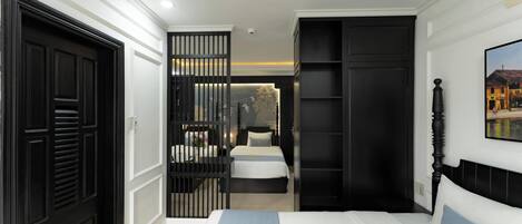 Habitación de hotel con cama, armario, escritorio y vista a un edificio.