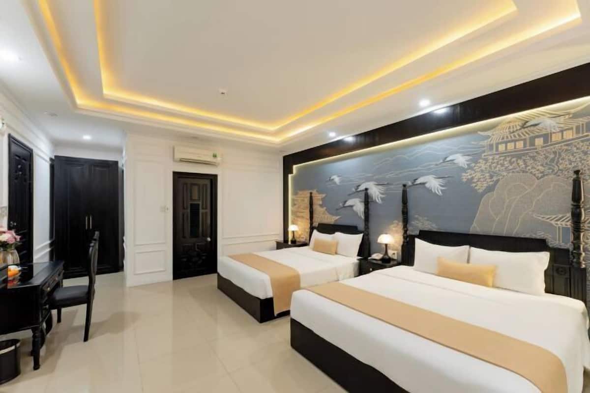 A hotel room with two beds, a dining table, and a mural on the wall.