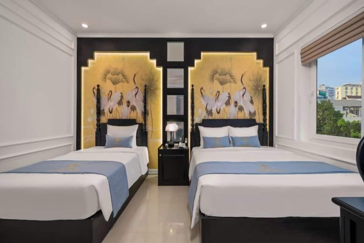 A hotel room with two beds, a nightstand, a lamp, and a decorative wall panel.