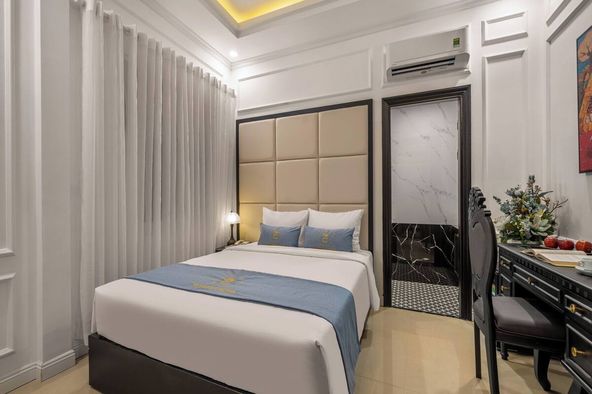A hotel room with a bed, a desk, and a chair.