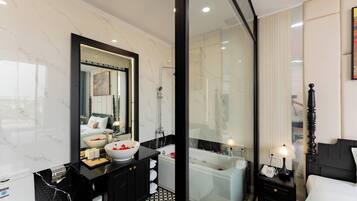 Executive studio | Badkamer | Een douche, een regendouche, designer toiletartikelen, een haardroger