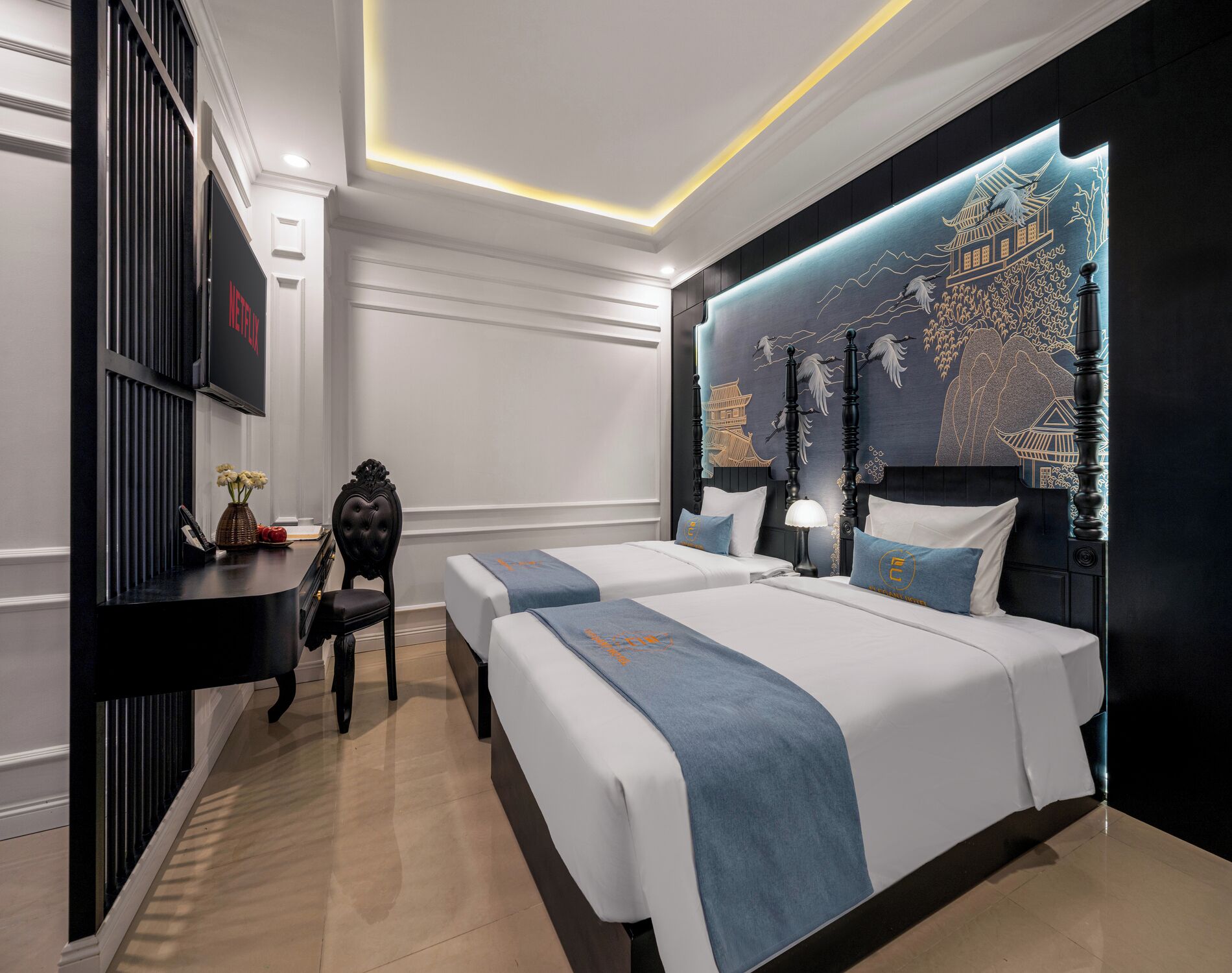 Una habitación de hotel moderna con dos camas, un escritorio y un adornado muro.