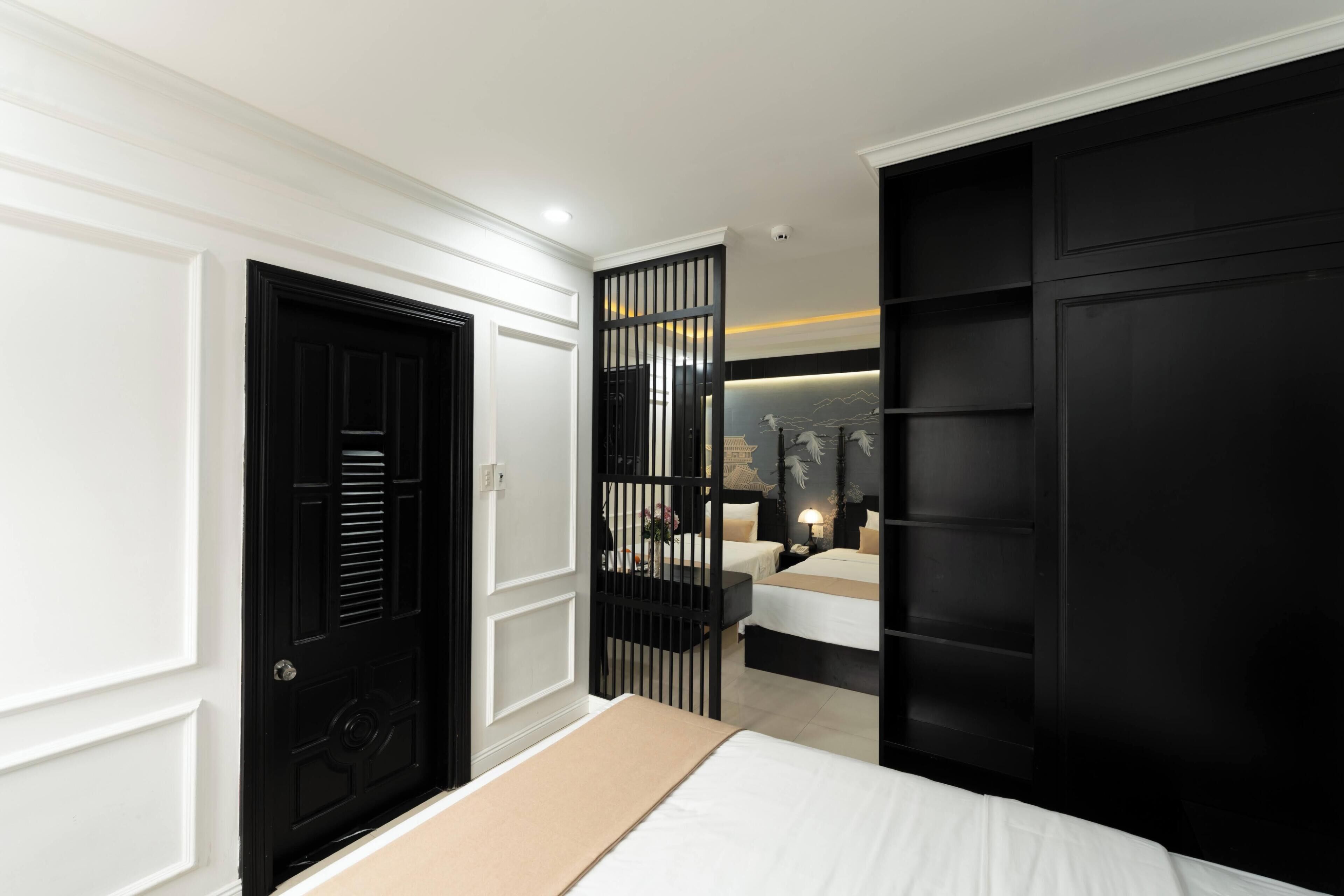 A bedroom with a bed, a wardrobe, a desk, and a nightstand.