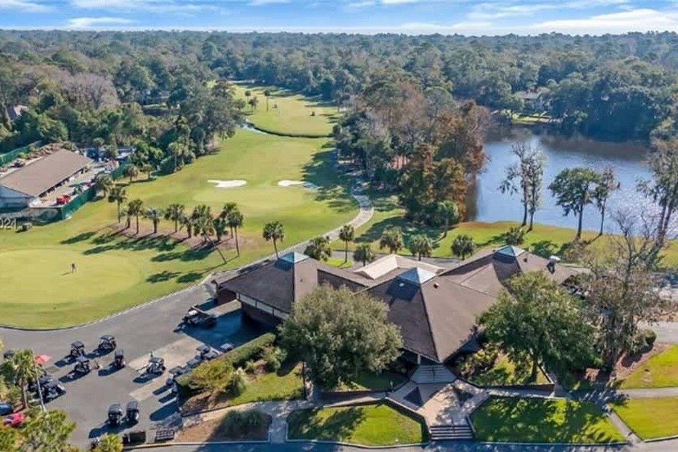 Un parcours de golf doté d’un club-house, d’un parking et d’un plan d’eau.
