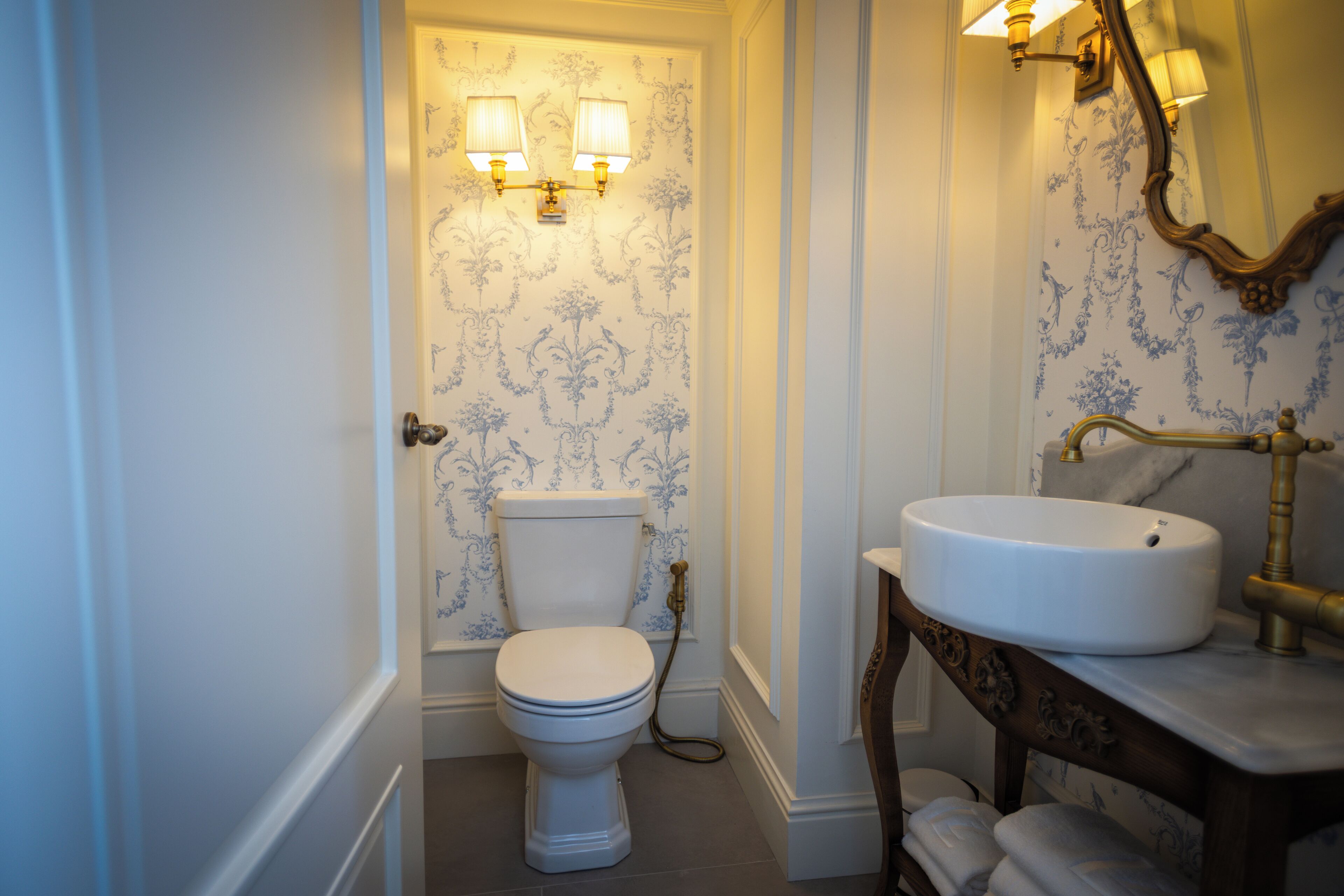 A bathroom with a toilet, a sink, and a mirror.