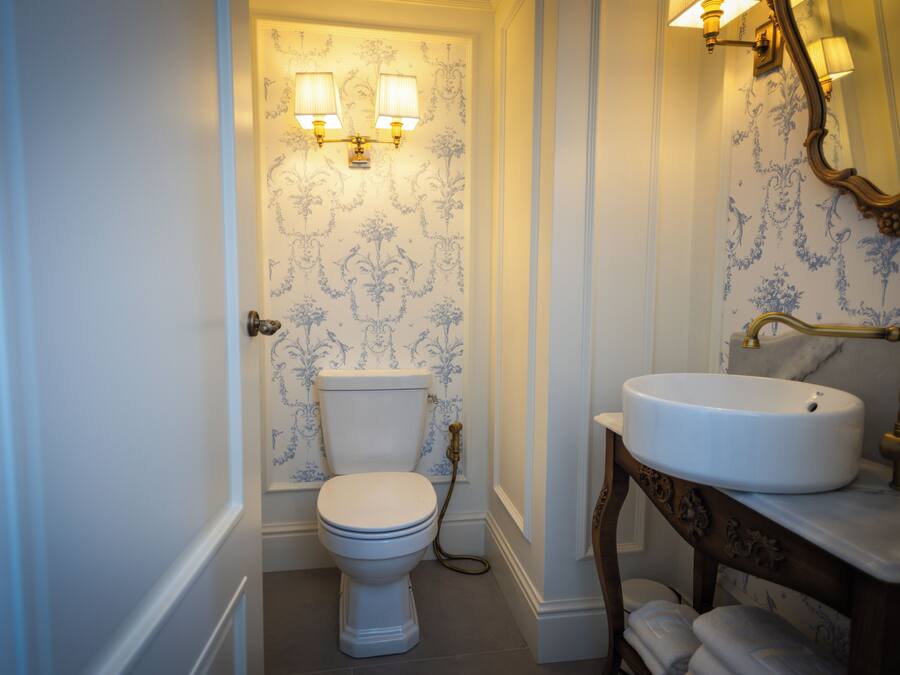A bathroom with a toilet, a sink, and a mirror.