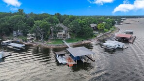 A lakeside property with docked boats, a house, and a gazebo.
