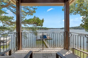 A covered outdoor area with a view of a lake, a dock, and boats. - Ultra-Luxury Waterfront Retreat on Duck Creek Oklahoma (Afton)