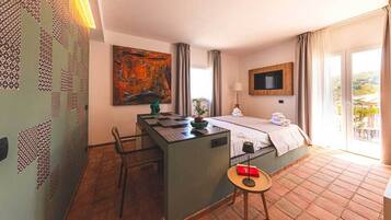 A hotel room with a bed, a desk, a chair, a TV, and a balcony with a view.