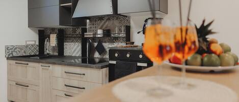 A kitchen with a modern design, featuring a stove, oven, and a dining area with a table set for a meal.