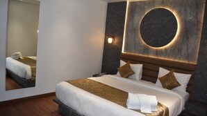 A hotel room with a large bed, a round mirror, and a modern wall design. - 3AG HOTEL & RESORT (Faizabad)