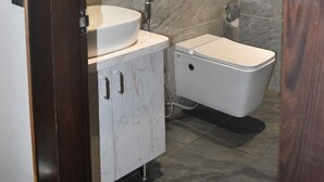 A modern bathroom with a marble wall, a sink, and a toilet. - 3AG HOTEL & RESORT (Faizabad)
