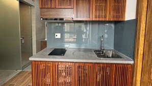 Una cocina moderna con una isla integrada, electrodomésticos de acero inoxidable y una pared de acento de madera.