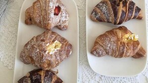 A table with pastries including croissants and donuts on a lace tablecloth. - MARE Tropea Boutique Rooms (Tropea)