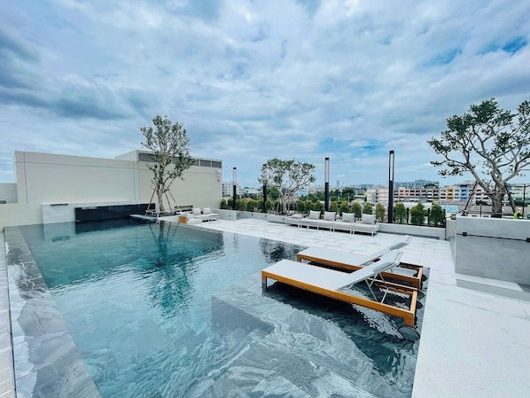 Una piscina al aire libre, tumbonas