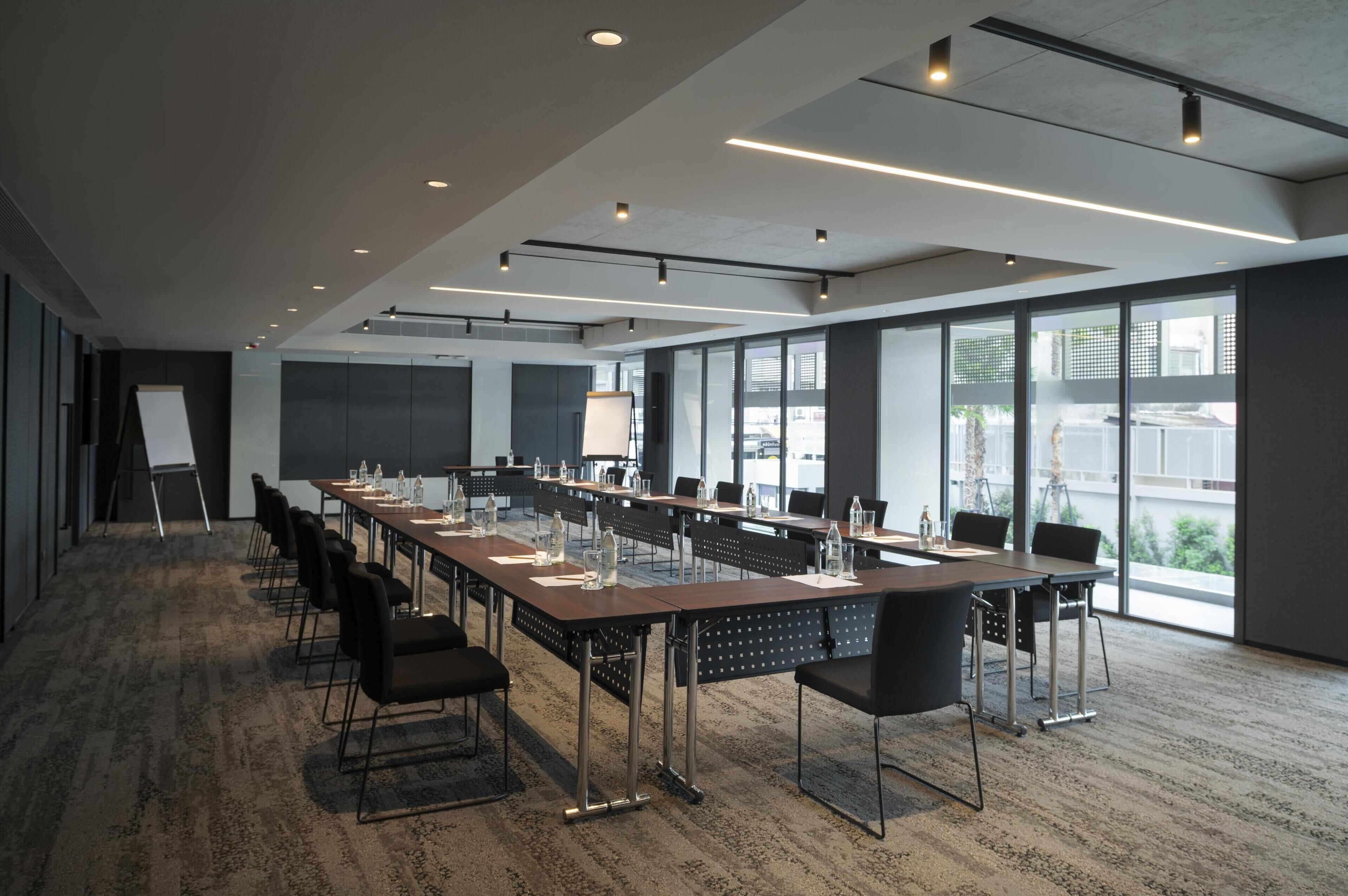 A conference room with long tables, chairs, and a whiteboard.