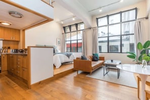 A modern interior with a kitchen, a bed, a sofa, and a dining area. - Stylish Studio in Centre by Zodiak Stay (Auckland)