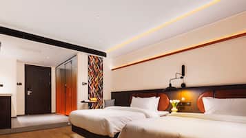 Quarto de hotel moderno com duas camas, piso de madeira, luminária fixada na parede e porta que dá para outro quarto.