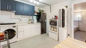 A compact kitchen with a washing machine, a microwave, and a refrigerator. - Stylish Itaewon Getaway | Spacious Living, Projector, 4 Beds, 5 min to Station (Seoul)