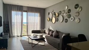 A modern living room with a sofa, coffee table, and a wall adorned with decorative plates.
