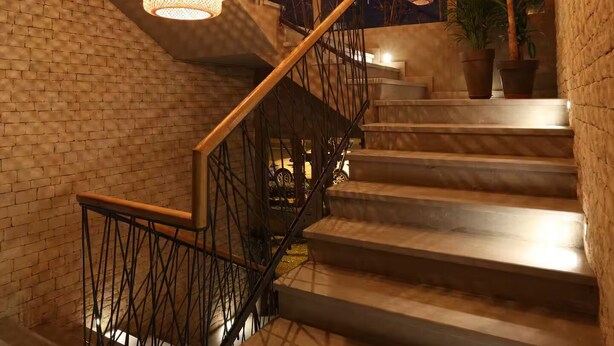 A staircase with a metal railing and hanging woven light fixtures.