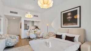 Une chambre d’hôtel moderne équipée d’un grand lit, d’un bureau, de deux chaises et d’un coin repas.