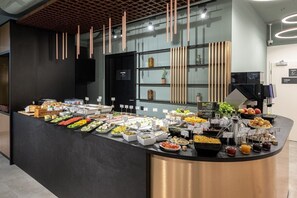 Un área de bufé con diversas opciones de comida y una estación de café.