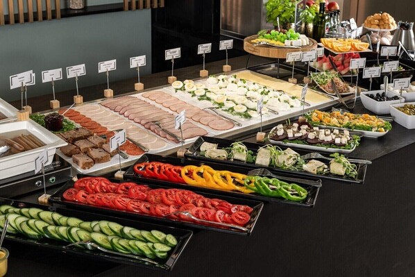 A buffet with various food options including meats, cheeses, salads, and vegetables. - B&B HOTEL Leszno (Leszno)