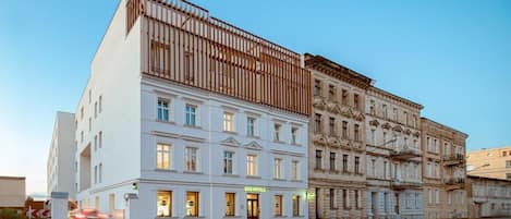 Un edificio moderno con un letrero de B&B, arquitectura clásica y vista a la calle.