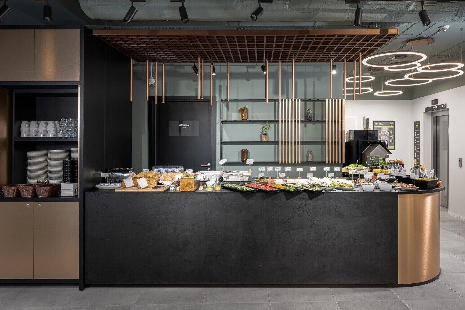 Una mesa de buffet moderna con diversas opciones de comida y una estación de café.