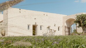 Un edificio blanco con un gran arco, una puerta y una ventana pequeña.